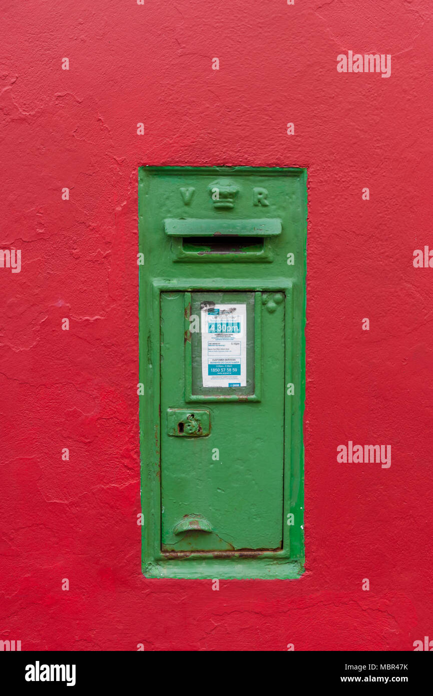 Post box irlandais dans un mur rouge dans la région de West Cork, Irlande avec copie espace. Banque D'Images
