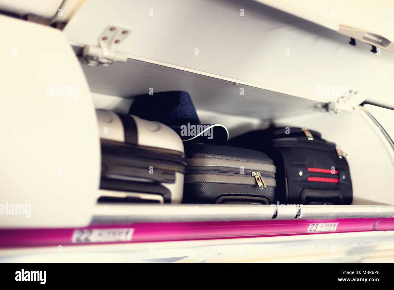 Coffre à la main avec des valises en avion. Les bagages à main sur la tablette du haut de l'avion. Travel concept with copy space Banque D'Images