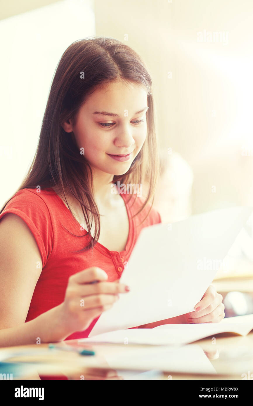 Happy student girl avec papier d'essai à l'école Banque D'Images