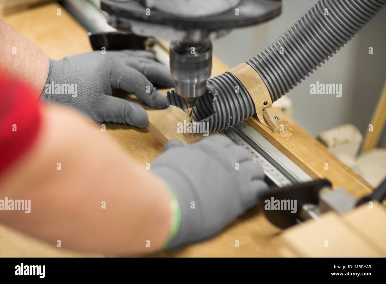 Carpenter avec la perceuse et le conseil à l'atelier Banque D'Images