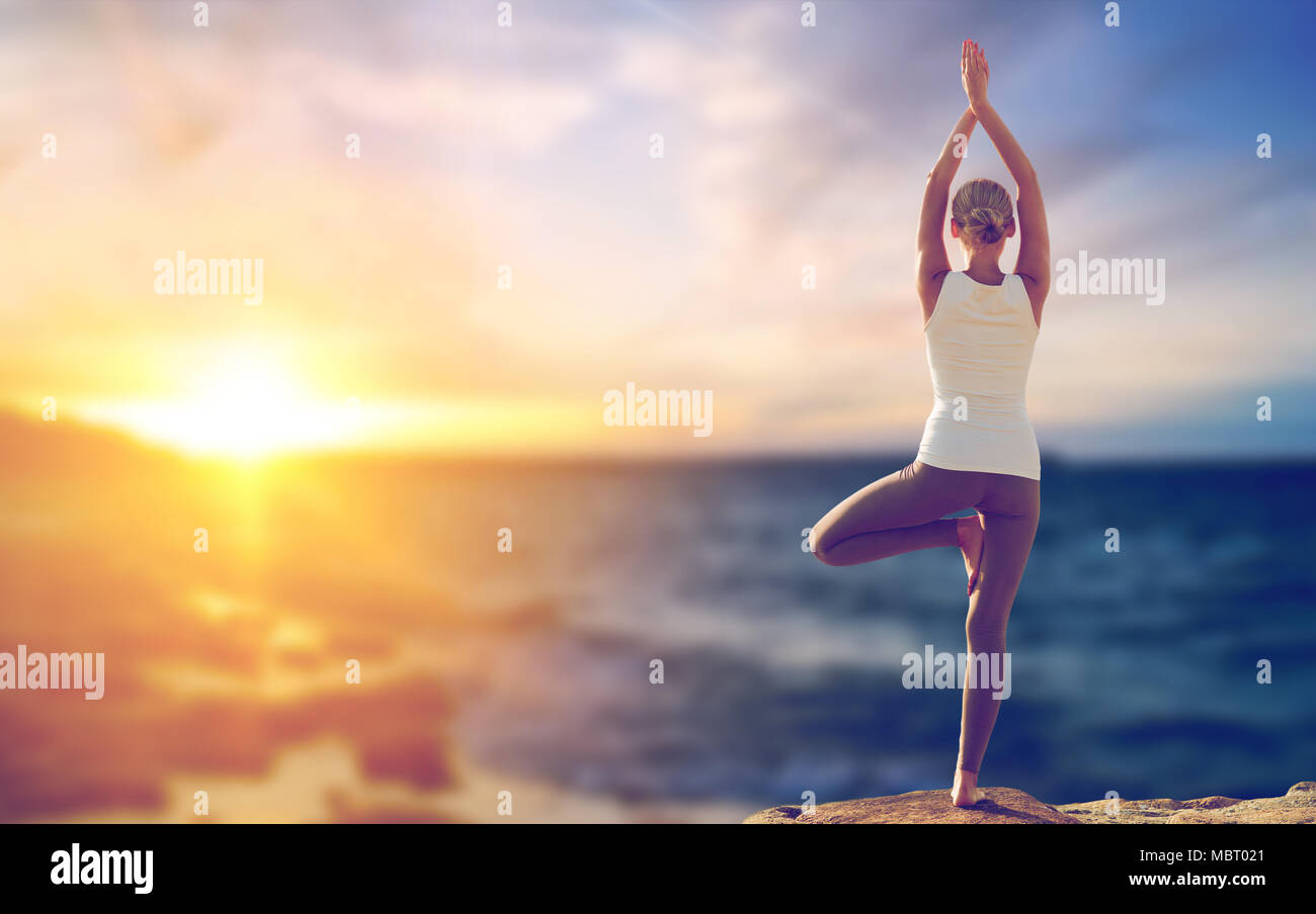 Happy woman yoga posture de l'arbre au-dessus de la mer Banque D'Images