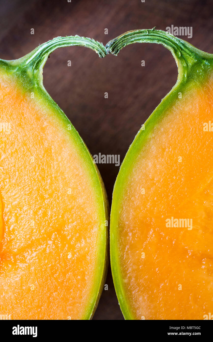 L'espace entre les deux moitiés d'un melon et de la tige forme une forme de coeur. Banque D'Images