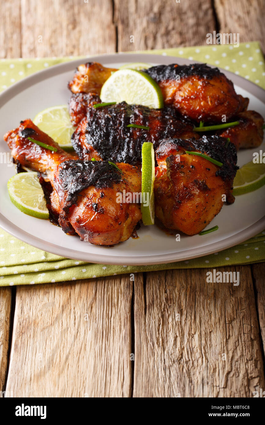 Poulet grillé au citron vert et les oignons du pilon libre sur une plaque sur une table verticale. Banque D'Images