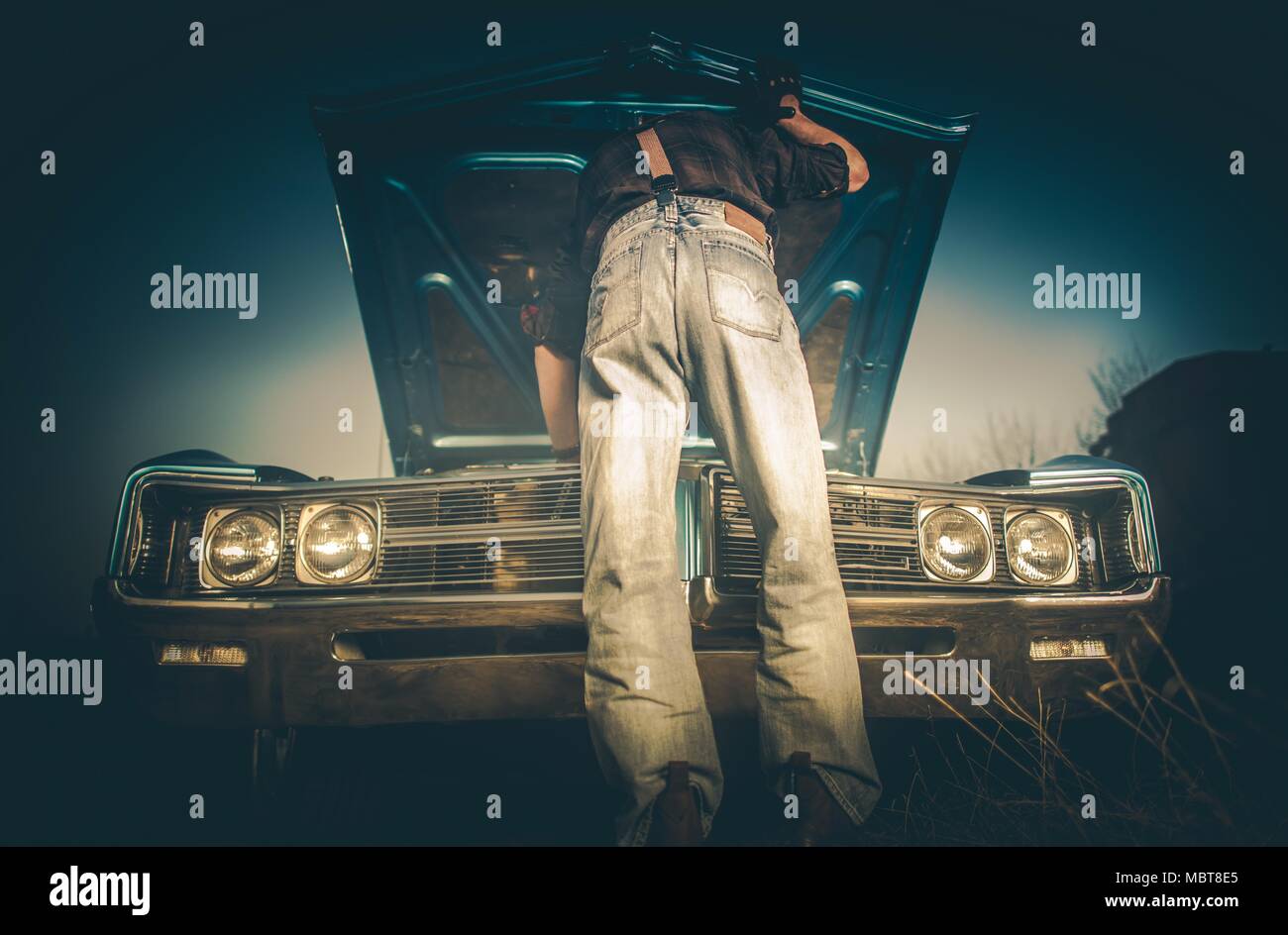 Casse fixation voiture de collection sur le côté de la route de campagne par les hommes de race blanche portant des vêtements de style occidental. Cowboy et son Vintage Ride. Banque D'Images