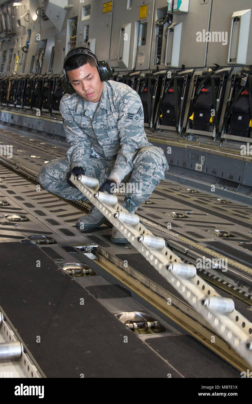 Le Boeing C-17 Globemaster III est un avion de transport stratégique à quatre moteurs développé par McDonnell Douglas et produit plus tard par Boeing pour l'United States Air Force, propulsé par des turboréacteurs Pratt & Whitney F117-PW-100. L'image d'archive documente le personnel de la réserve de l'Armée de l'Air ajustant les rails de roulement à l'intérieur de la soute durant l'entraînement avec la Garde nationale aérienne d'Hawaï à la base conjointe Pearl Harbor-Hickam le 7 janvier 2018. Banque D'Images