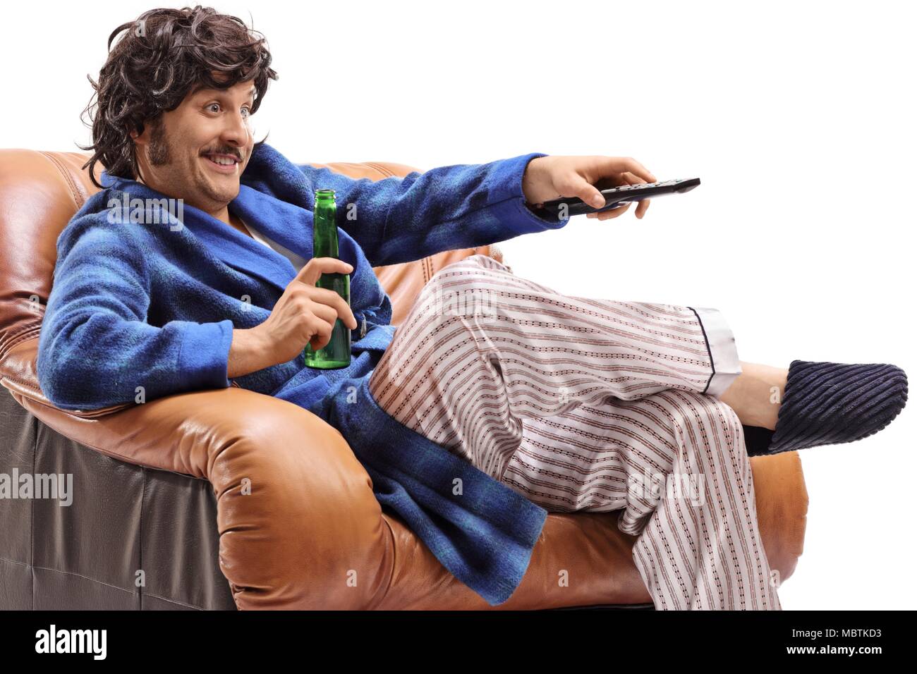 Homme avec une bouteille de bière assis dans un fauteuil et regarder la télévision isolé sur fond blanc Banque D'Images