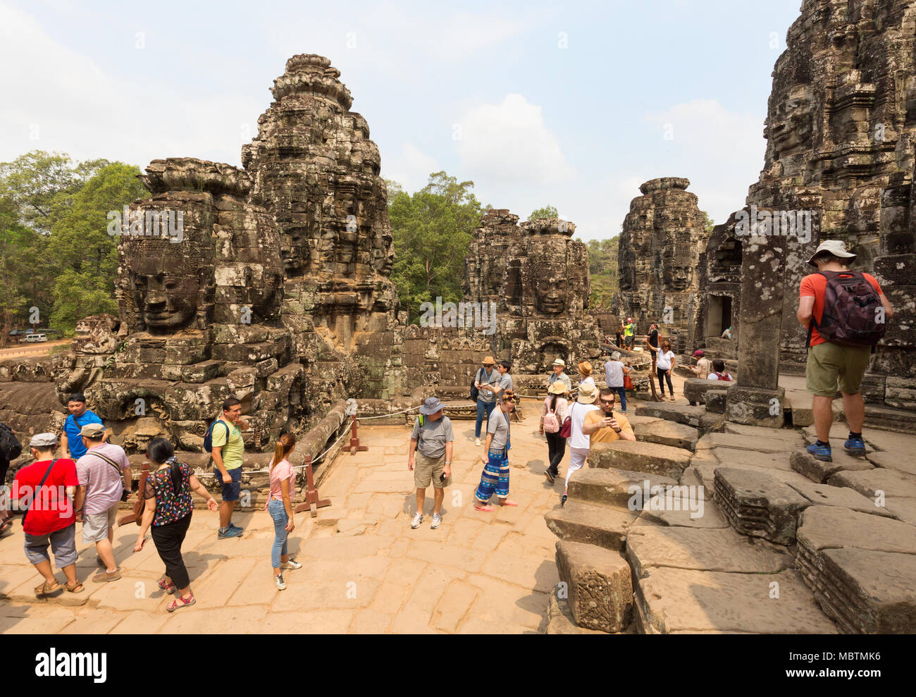 Temple Bayon Cambodge - les touristes à la recherche de visages sculptés au Bouddha, temple Bayon, Angkor Thom, site du patrimoine mondial de l'UNESCO, le Cambodge, l'Asie Banque D'Images