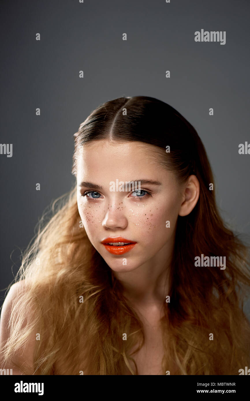 Portrait de jeune fille belle en studio, avec maquillage professionnel.le  tournage de beauté. Portrait de beauté d'une belle jeune fille avec de  l'orange vif.la peau des lèvres de rousseur d'Or Photo Stock -