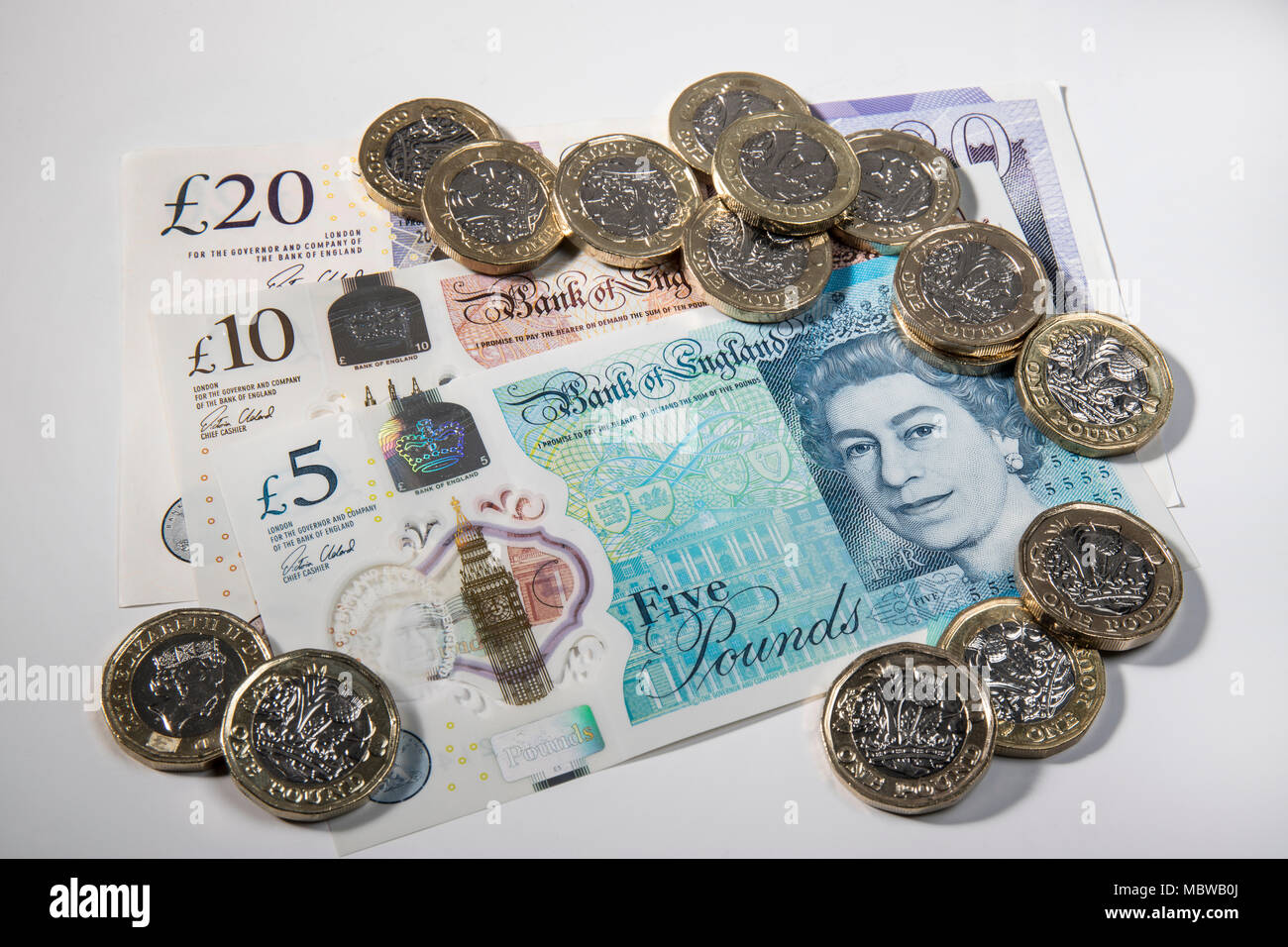 €1 pièces placées aléatoirement sur UK £5, £10, £20 et note Banque D'Images