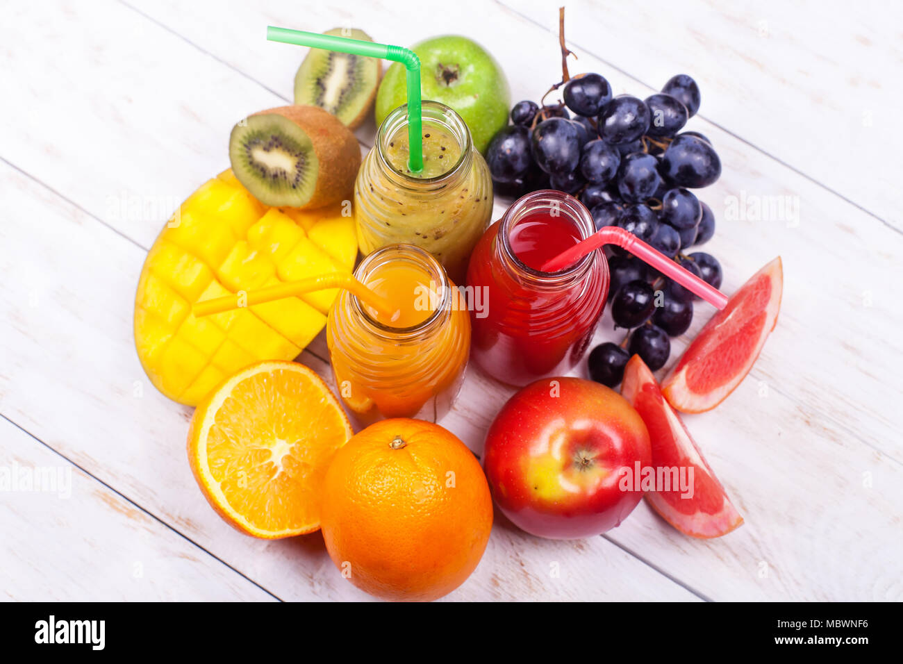 Des jus de fruits Smoothie trois bouteilles Rouge Vert Orange Fruits tropicaux de melon d'eau Raisin Kiwi Mangue Orange Apple Pine Apple Raisin Grenade Selective Banque D'Images