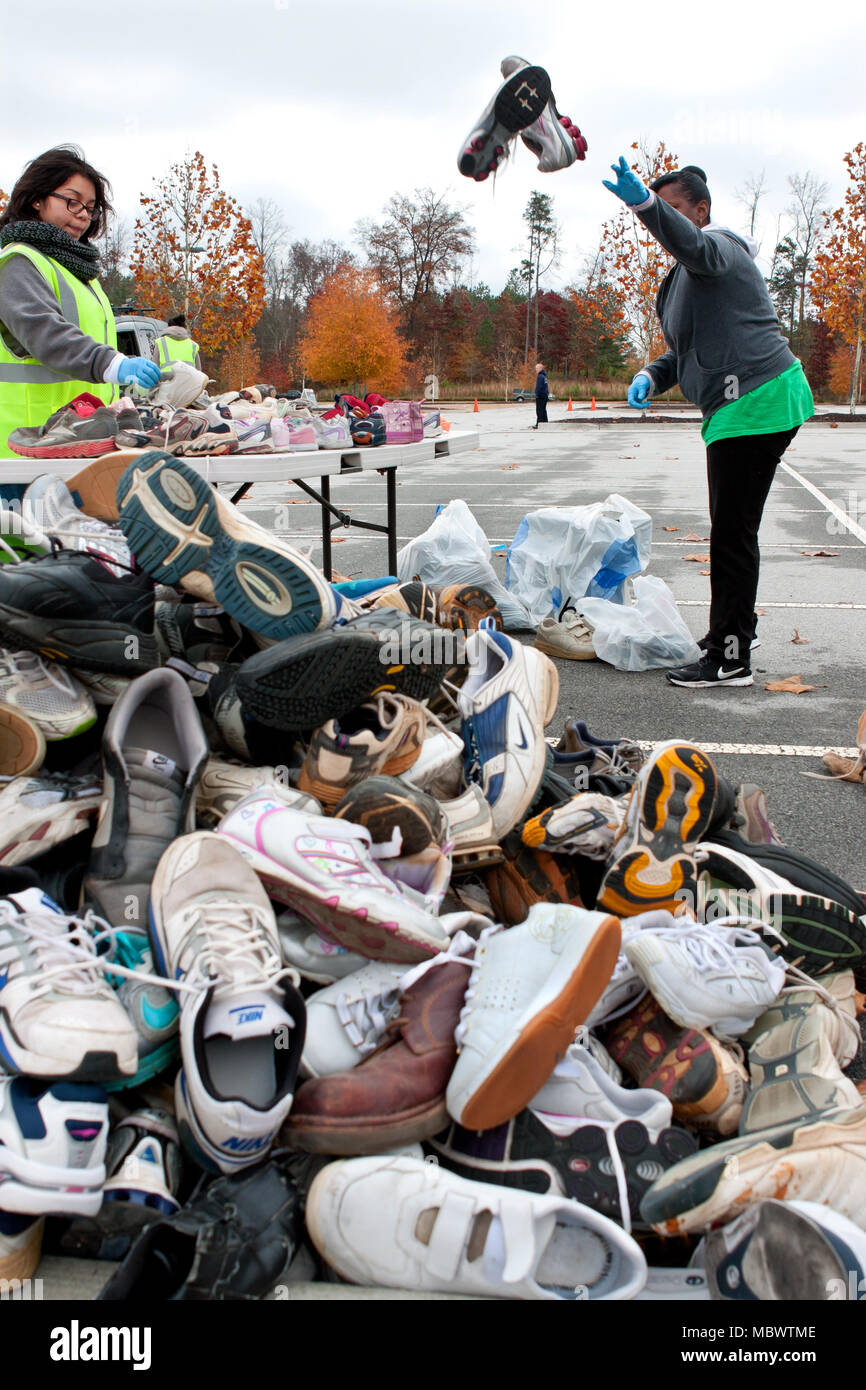 Trier les bénévoles et mélanger sneakers en un gros tas de chaussures à Gwinnett County's America Recycles Day le 23 novembre 2013 à Lawrenceville, GA. Banque D'Images
