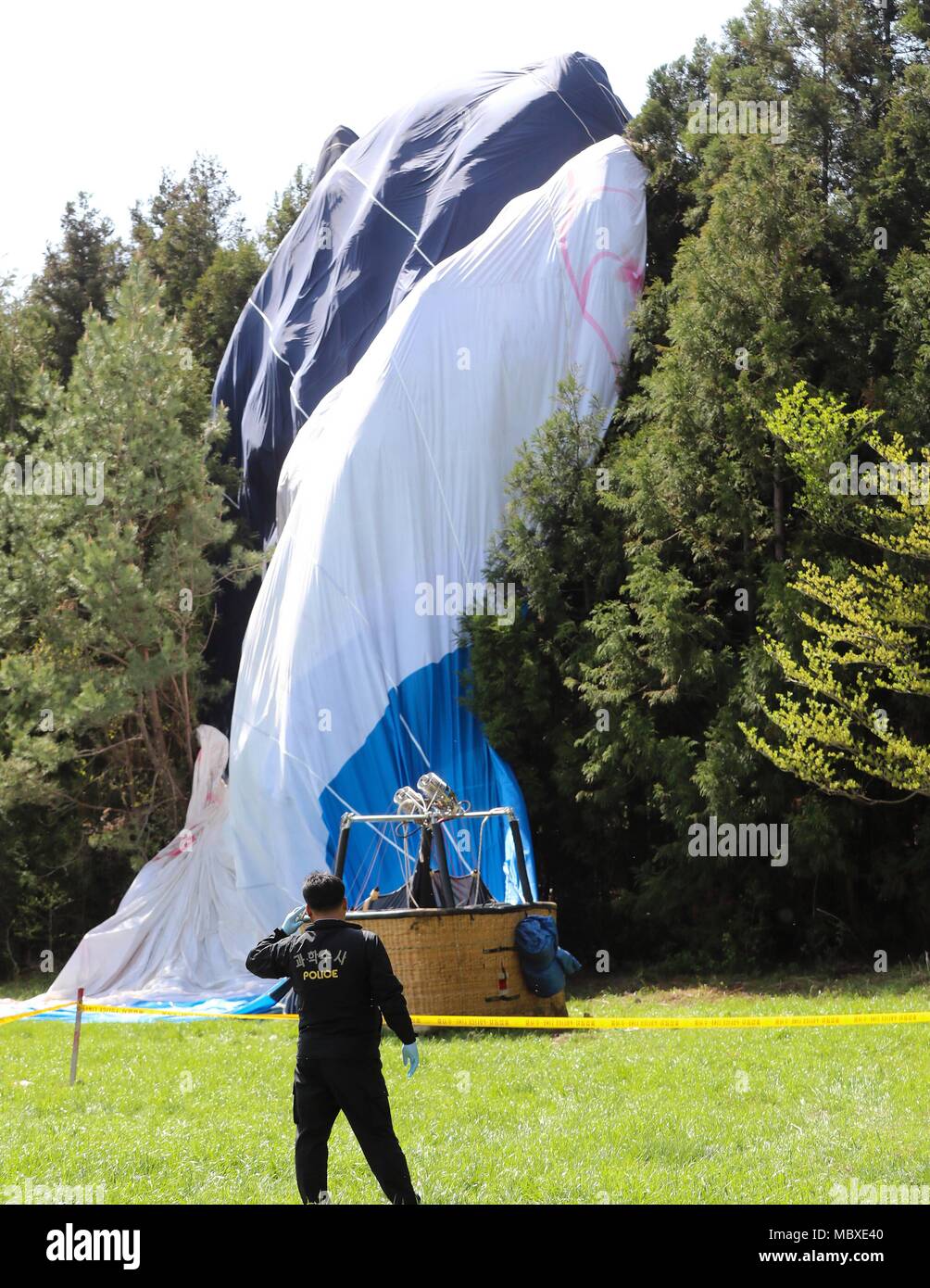 Jeju, Corée du Sud. Apr 12, 2018. Un policier travaille à la place d'un ballon à air chaud d'un crash dans l'île de Jeju, en Corée du Sud, le 12 avril 2018. Une personne a été tuée et 12 autres blessées dans un accident de montgolfière à l'atterrissage tôt jeudi. Credit : Newsis/Xinhua/Alamy Live News Banque D'Images