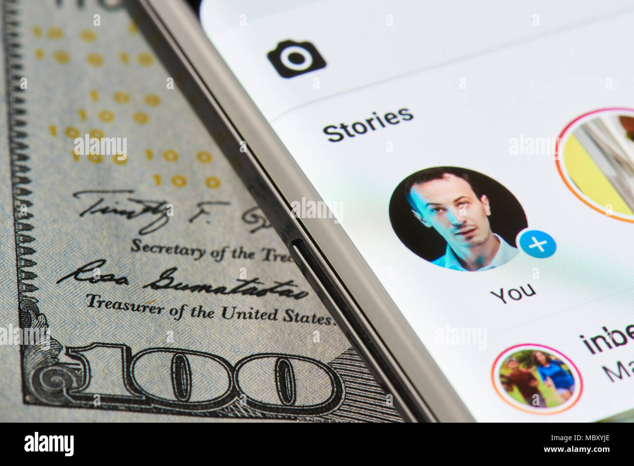 New York, USA - 11 Avril 2018 : histoire Instagram sur smartphone close-up sur fond de devises dollar Banque D'Images