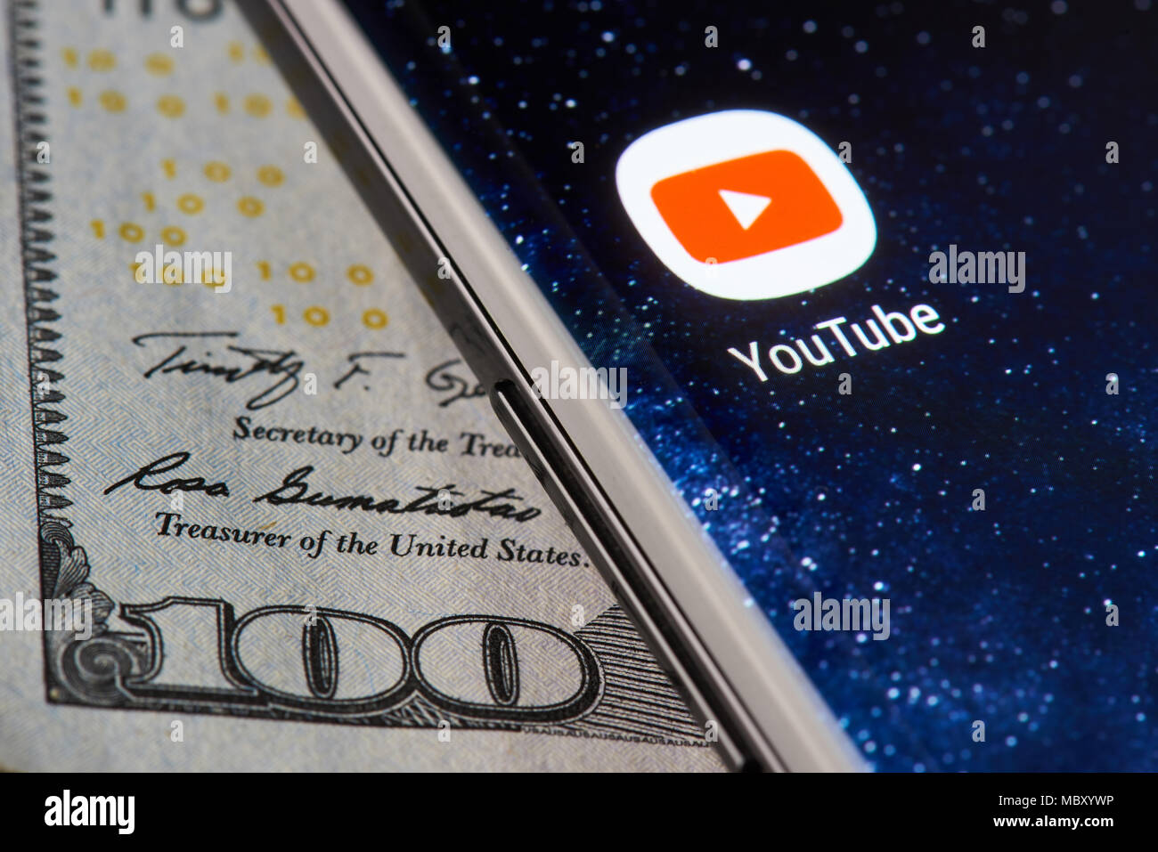 New York, USA - 11 Avril 2018 : l'icône Youtube app sur smartphone close-up sur fond de devises dollar Banque D'Images
