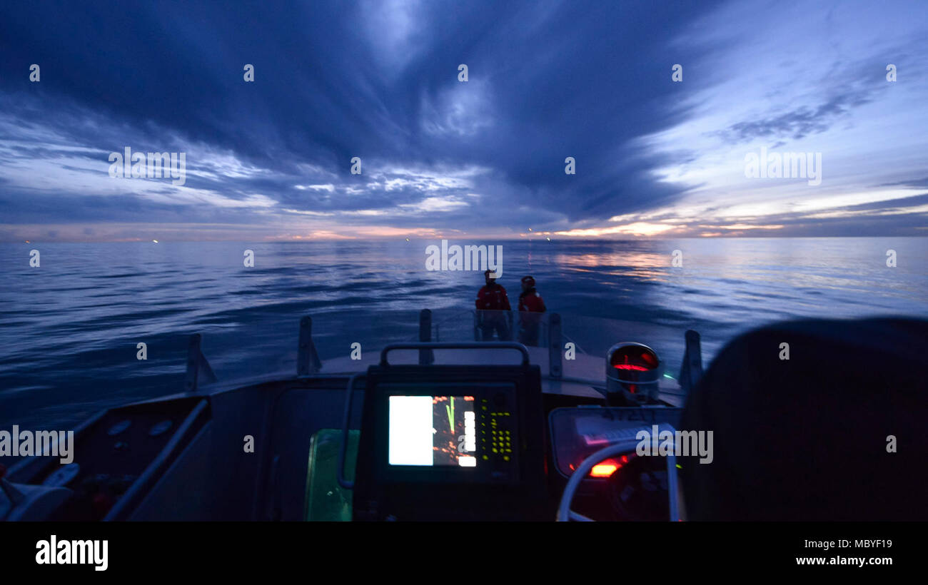 L'équipage de la Garde côtière à bord d'un bateau de sauvetage à moteur de 47 pieds à partir de la station de la Garde côtière canadienne Humboldt Bay debout sur la proue du bateau pendant qu'ils attendent pour le coucher du soleil pour commencer les opérations d'hélicoptère de nuit, de formation, le 6 mars 2018. Les équipages des hélicoptères de la Garde côtière canadienne effectuent couramment des équipages de petits bateaux avec formation de maintenir leurs qualifications et ainsi que dans le cas d'une évacuation sanitaire demande d'un bateau ou navire, les équipages sont compétents dans leurs techniques de sauvetage. (Garde côtière canadienne Banque D'Images