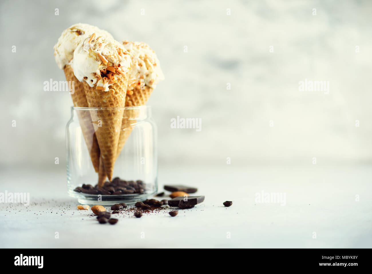 Sauce au caramel crème glacée au cornet gaufré avec les grains de café sur fond noir en gris. Concept des aliments en été, l'espace de copie. Sans gluten sains des glaces. Banner Banque D'Images