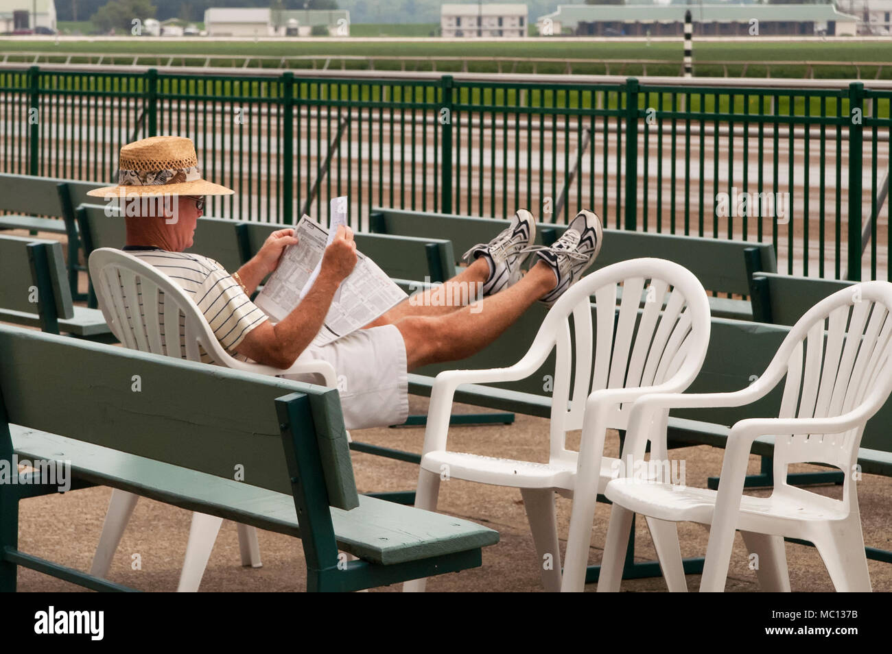 New York, USA - 20 août 2006 : Caucasian man lit les informations concernant les chevaux à l'Ellis Park race track comme il attend que le racing à b Banque D'Images
