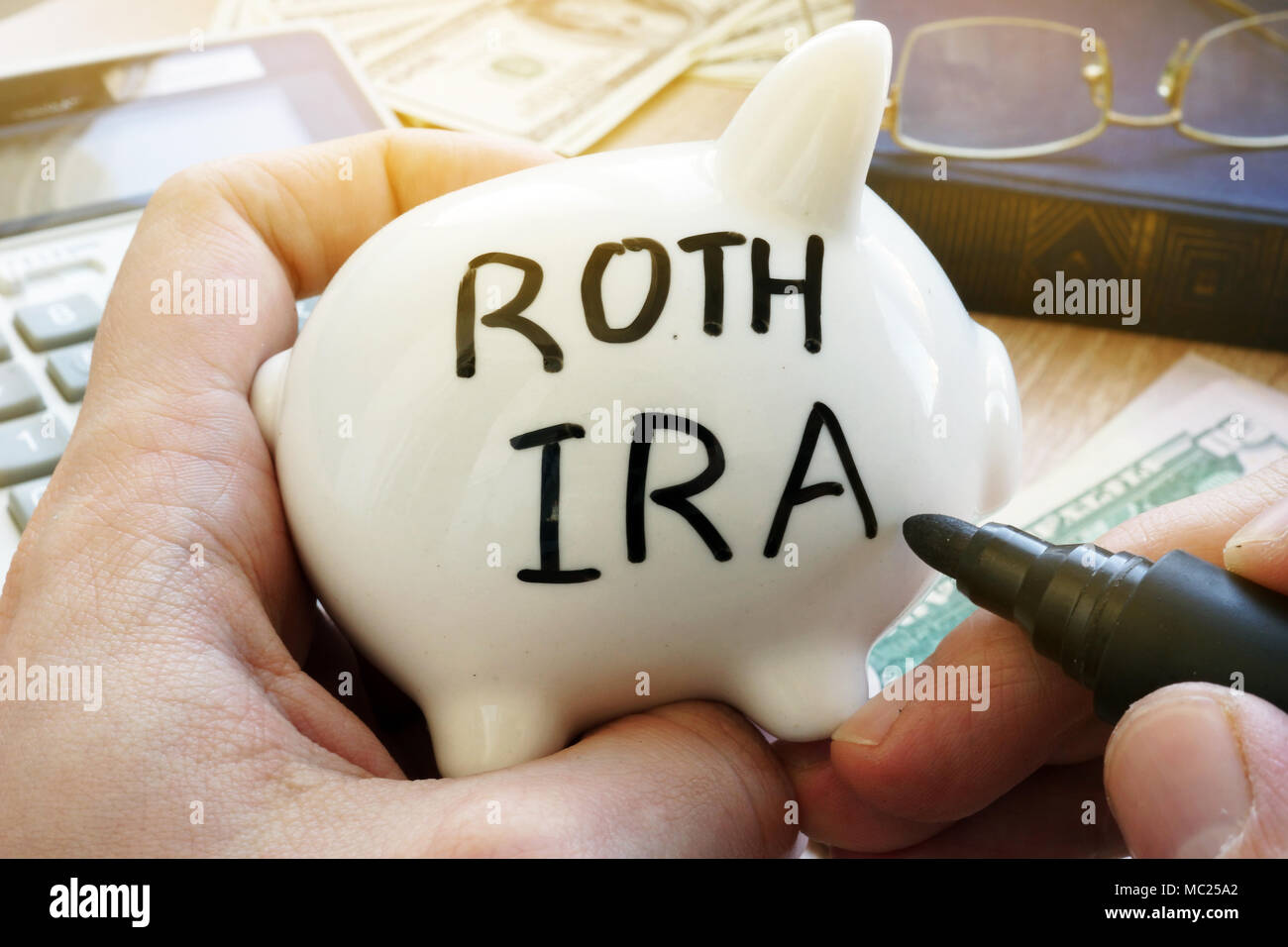Hands holding piggy bank avec Roth IRA. Régime de pension. Banque D'Images
