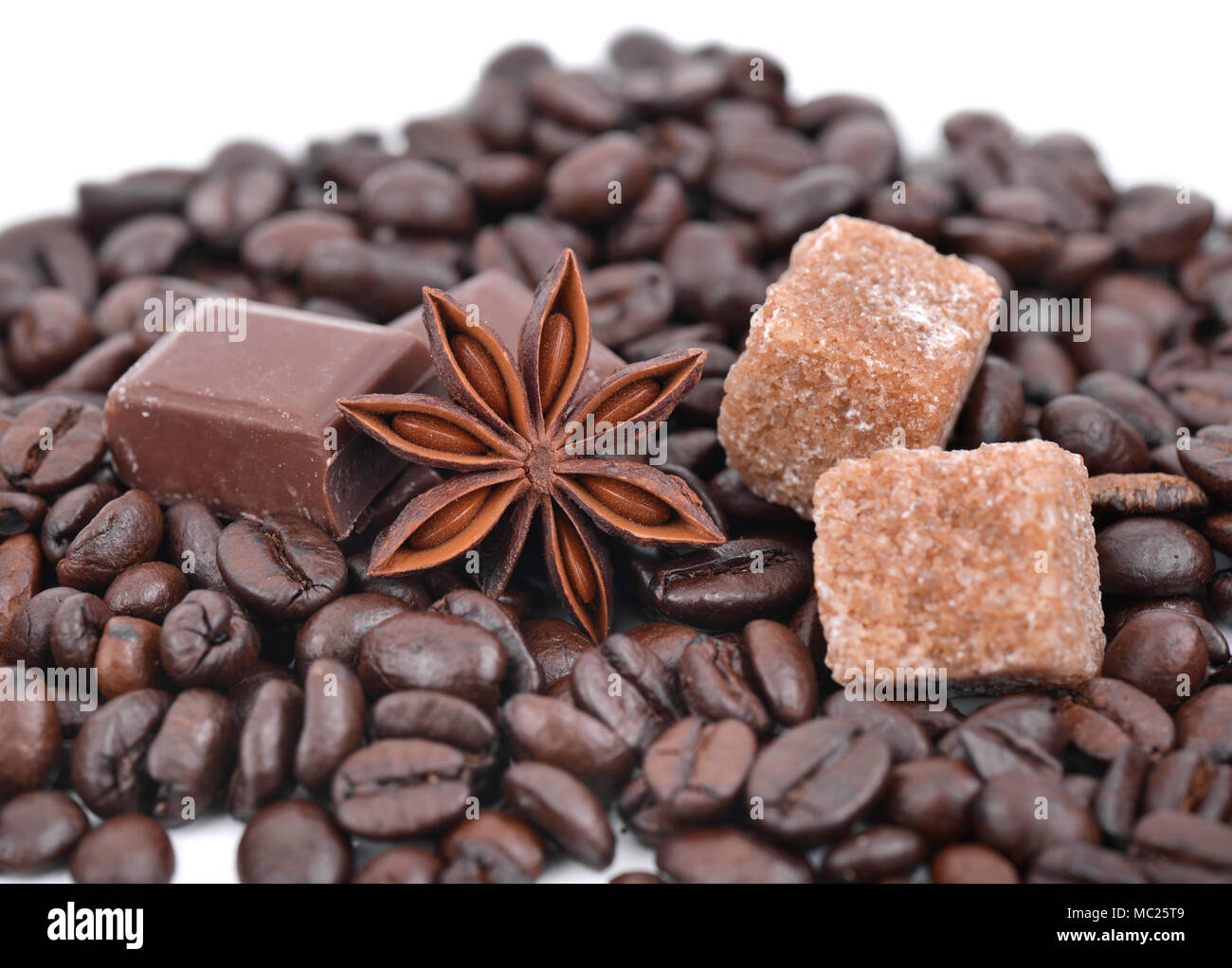 Étoile d'anis, chocolat et sucre en tas de grains de café Banque D'Images
