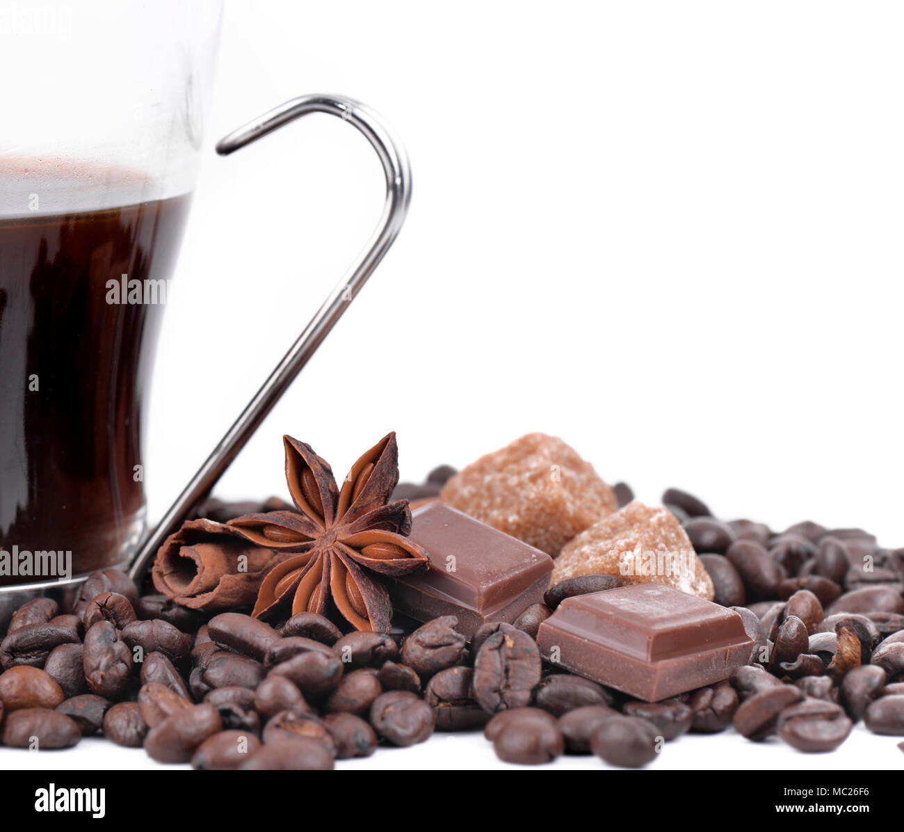 Grande tasse de café en grains de café, étoile d'anis, chocolat et sucre sur fond blanc Banque D'Images