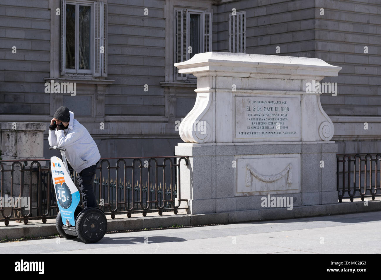 Guide Segway passer du temps au téléphone en attente à l'extérieur du Palais Royal de Madrid à proximité de Memorial pour le Dos de Mayo uprising Banque D'Images