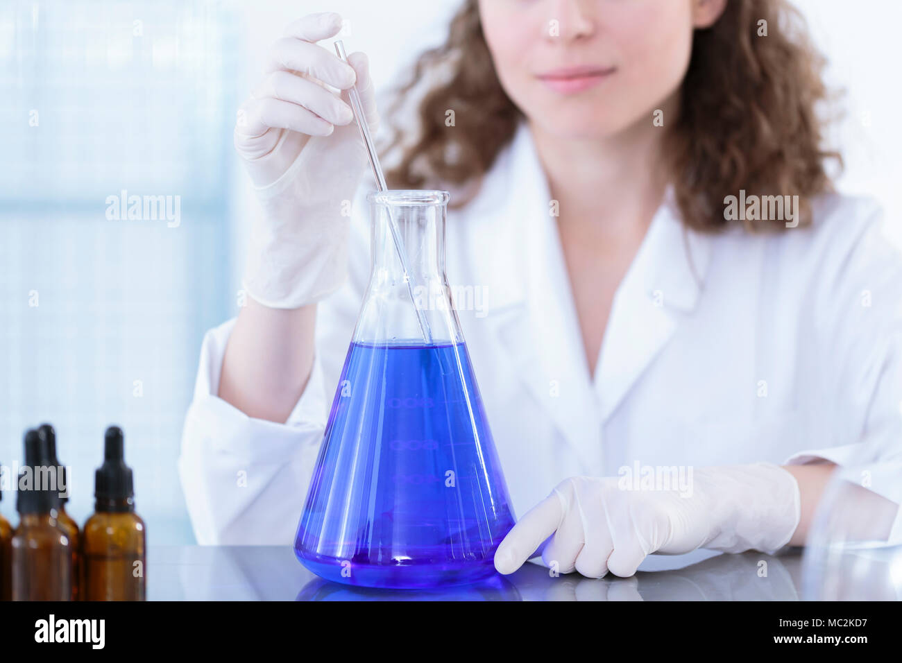 Technicien de l'ajout d'un échantillon avec une pipette à ballon avec une  solution bleue Photo Stock - Alamy