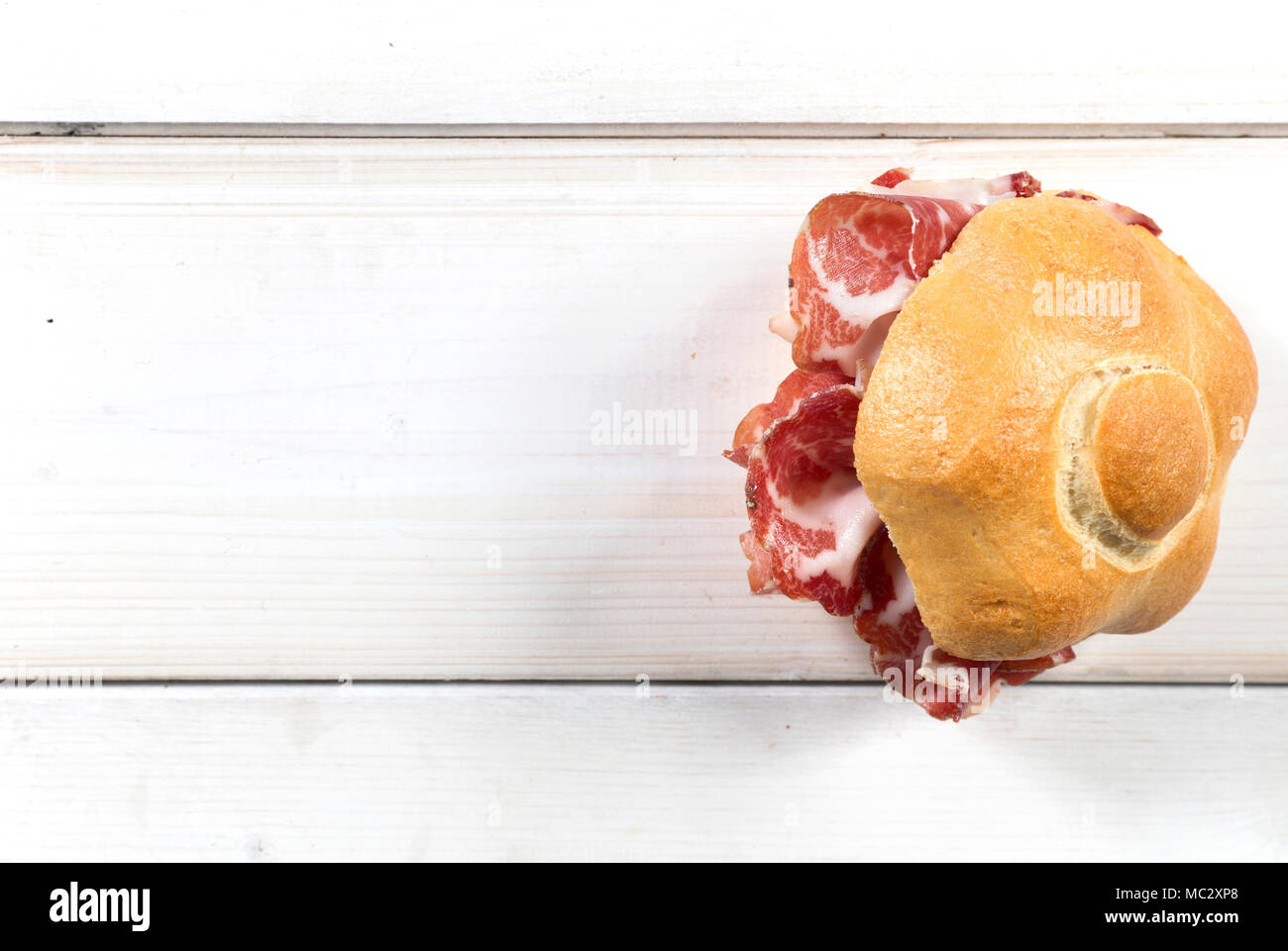 Télévision tourné d'un sandwitch italien typique avec coppa ( made in Piacenza, Italie du nord) sur une table en bois blanc, sous réserve d'un accent sur le droit Banque D'Images