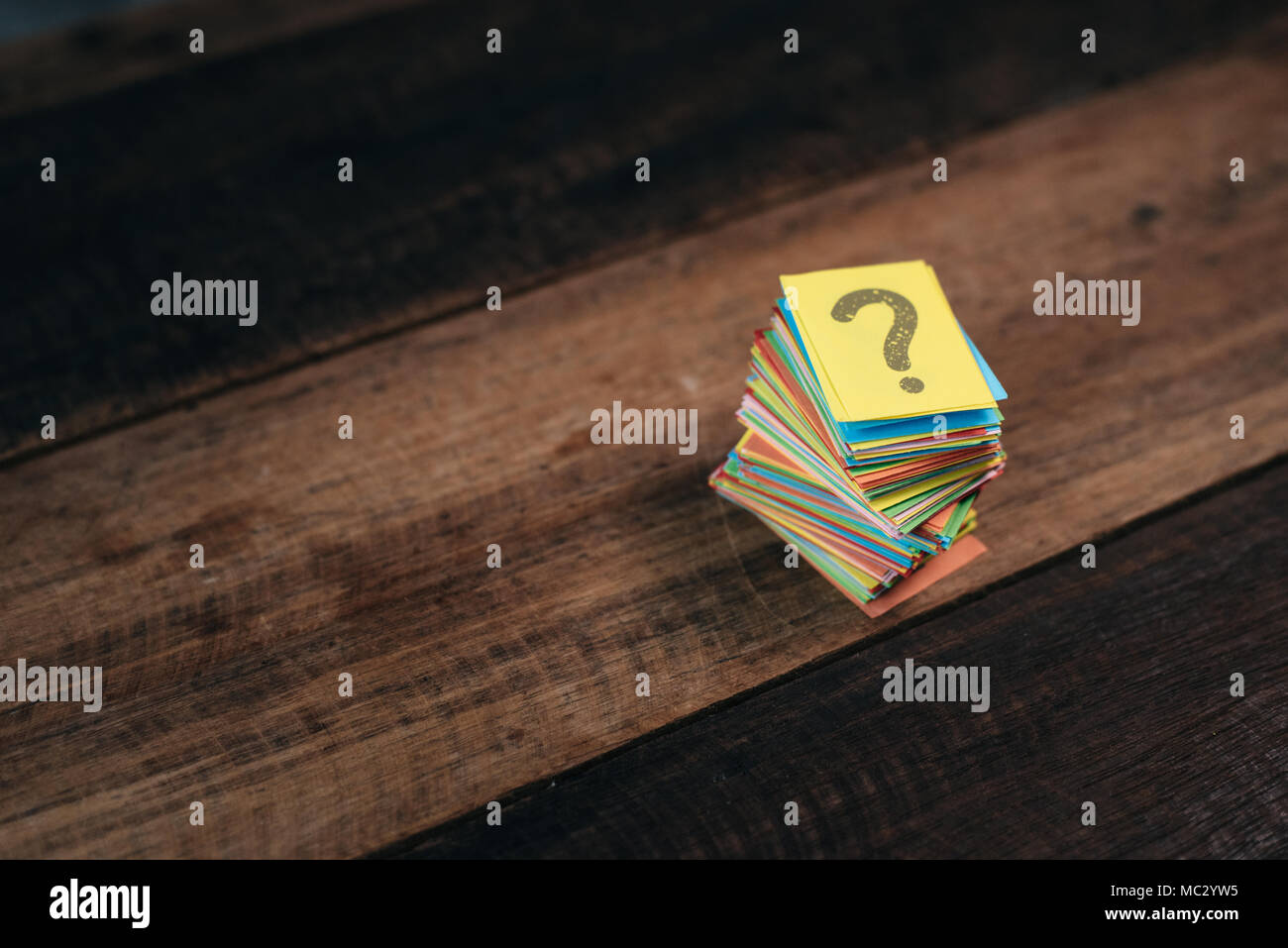 Papier multicolores avec point d'interrogation sur une table en bois fond. questions,mystère et concept de diversité. FAQ et Q&A concept d'arrière-plan Banque D'Images