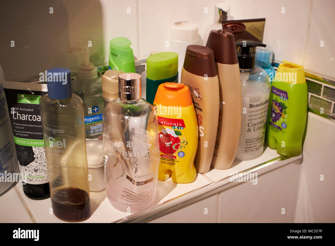 Gels et shampoings famille produits ménagers entassés dans une salle de bains au Royaume-Uni Banque D'Images
