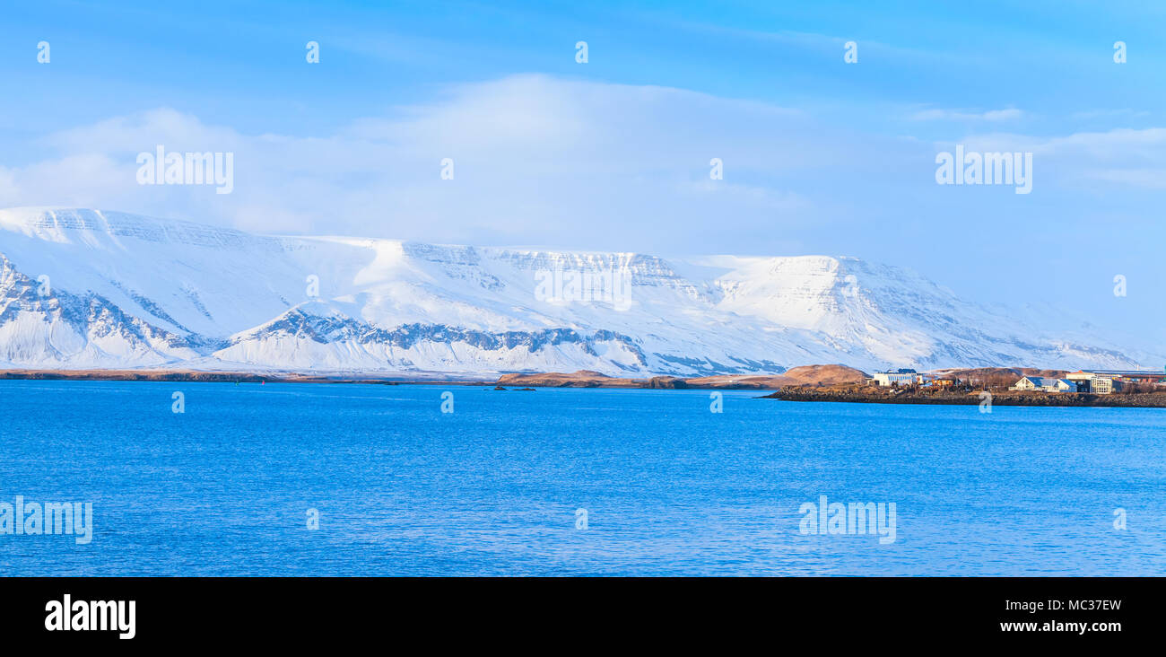 Paysage panoramique côtières islandaises. Montagnes enneigées sous ciel bleu foncé. Reykjavik, Islande Banque D'Images