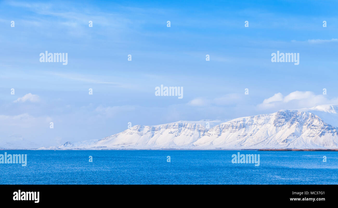 Paysage de la côte islandaise, montagnes enneigées sur horizon sous ciel bleu. Reykjavik, Islande Banque D'Images