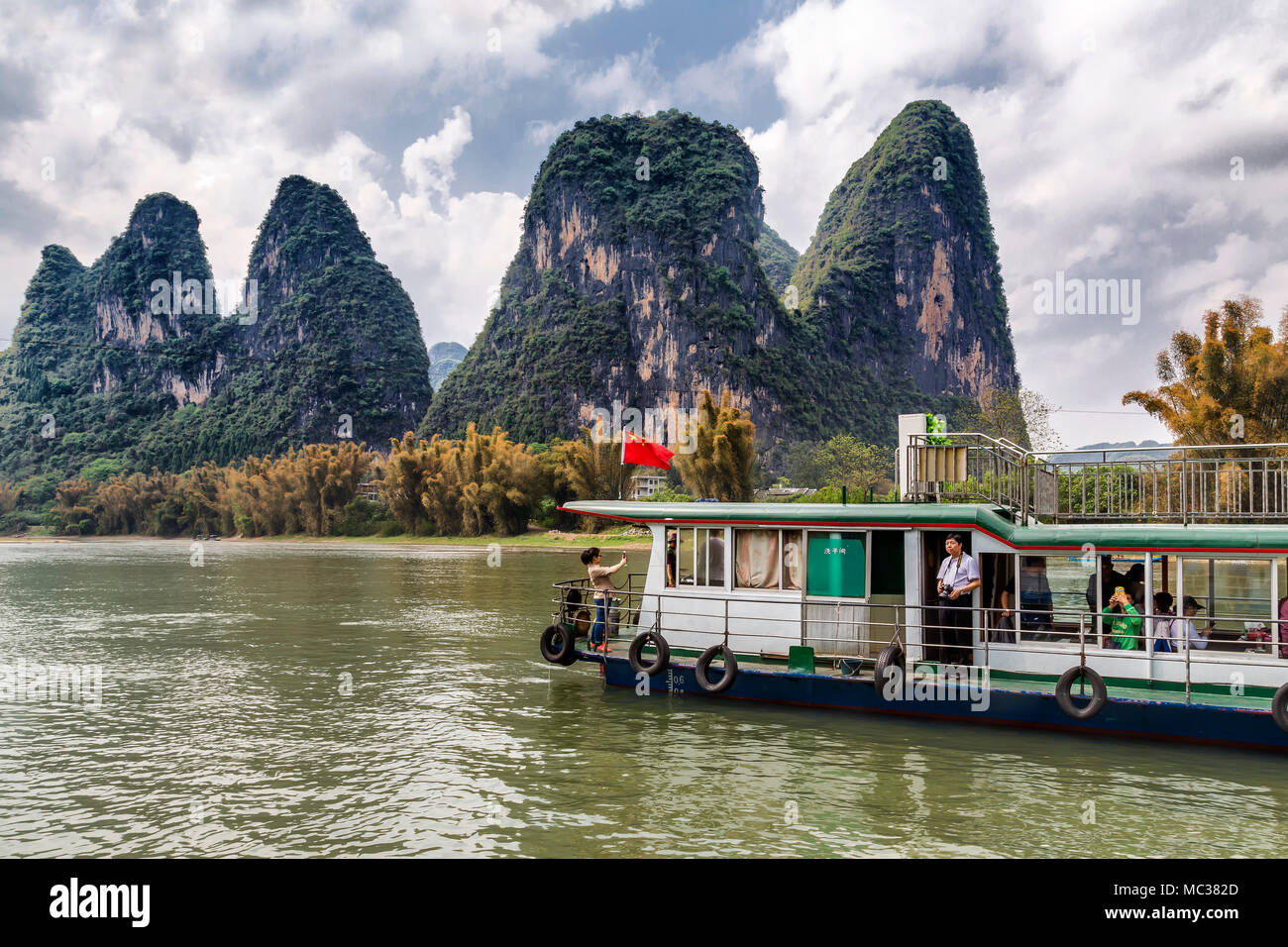 Un bateau de tourisme transporte des passagers le long de la rivière Li, Yanshuo, Chine. Elles donnent à la formation inhabituelle de la montagnes karstiques. Banque D'Images