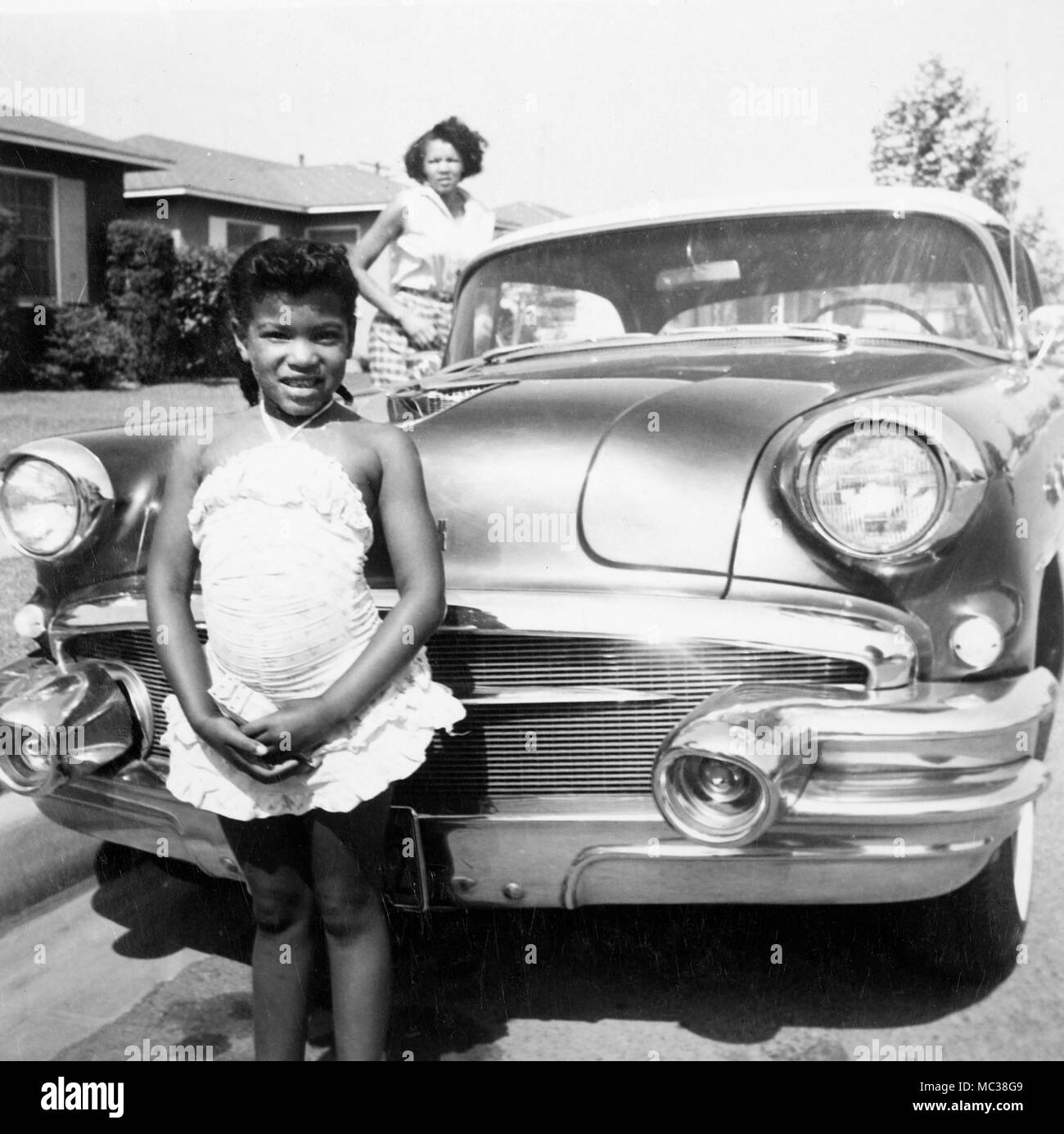 Une petite fille et sa mère se tenir par la voiture familiale en Californie, 1958. Banque D'Images