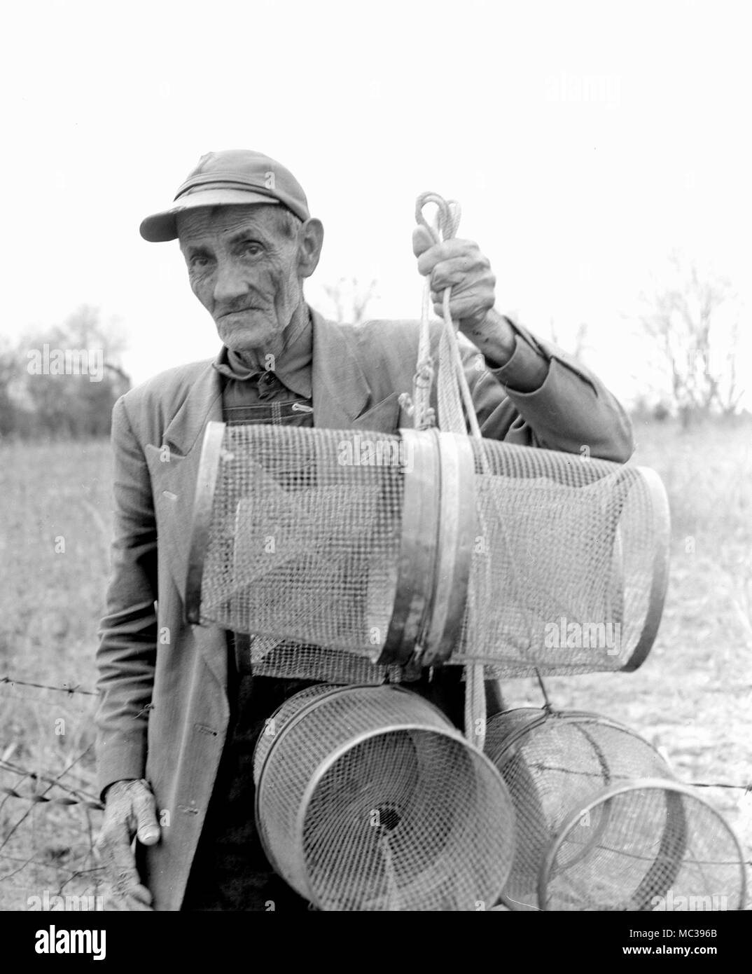 A senior man affiche les outils de son métier d'attraper bait-boule en Géorgie, ca. 1962. Banque D'Images