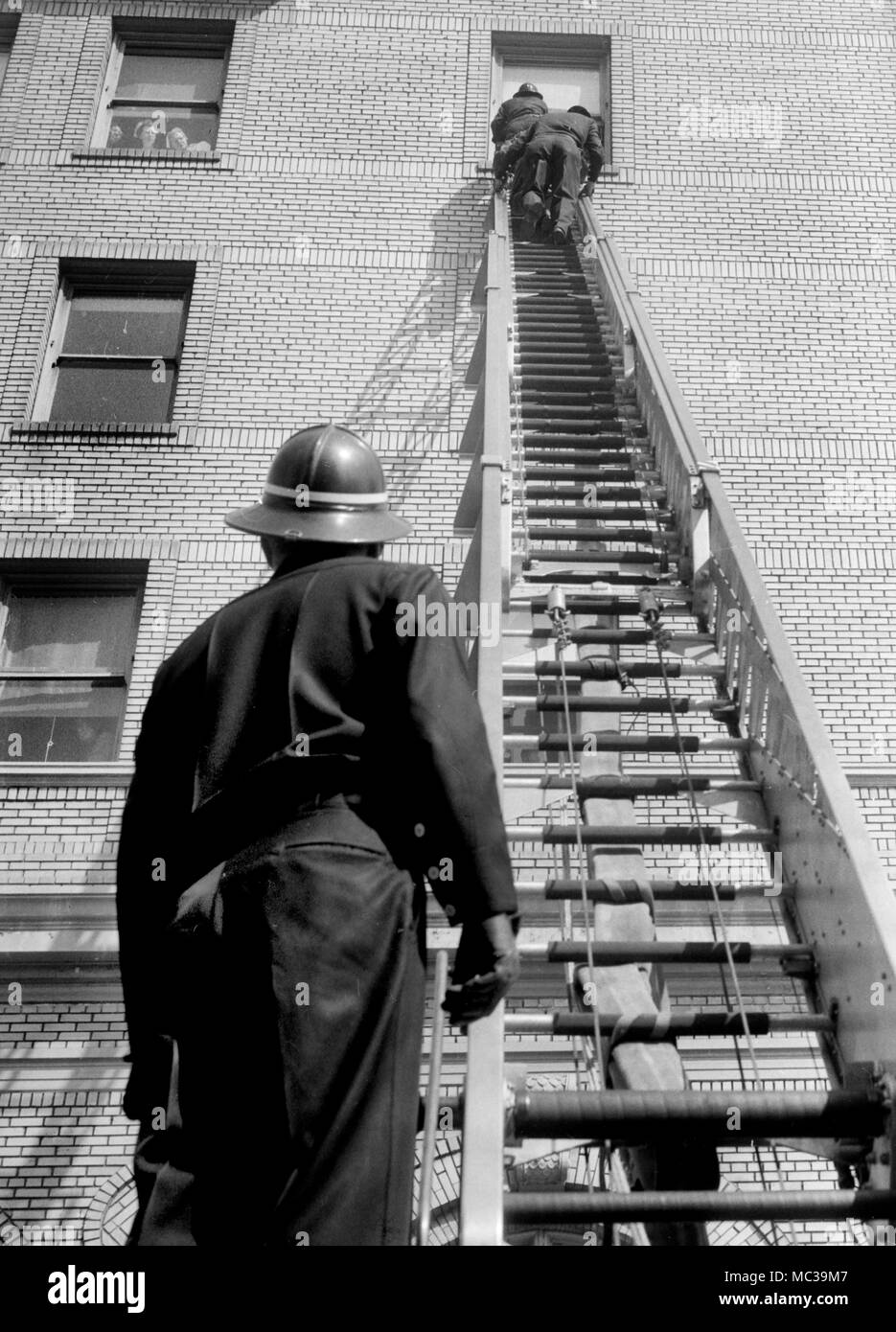 La pratique des pompiers sur une échelle d'incendie dans un hôpital de Californie, ca. 1965. Banque D'Images