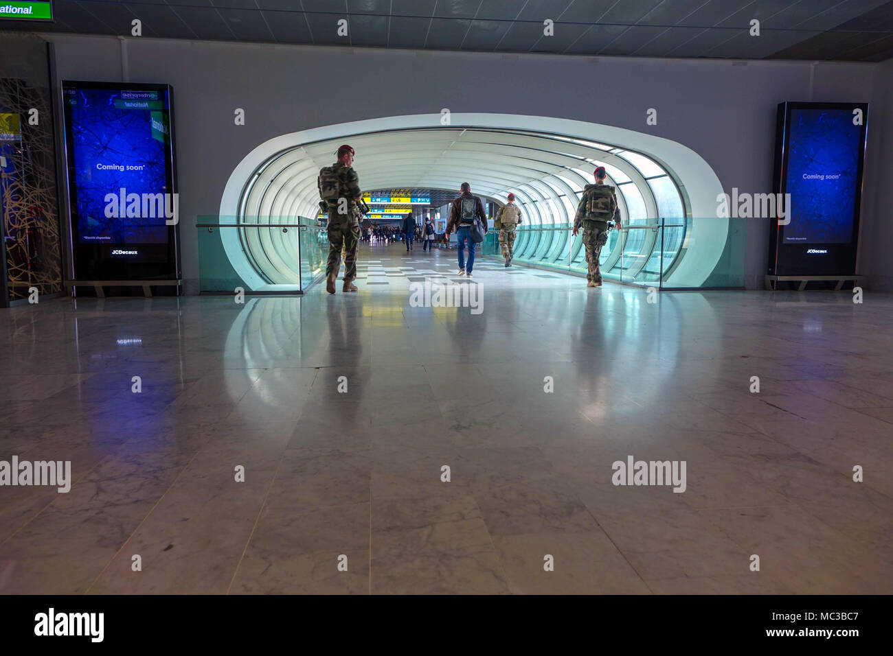 Tunnel pour piétons avec quatre soldats marchant à travers, l'aéroport de Toulouse Blagnac, France Banque D'Images