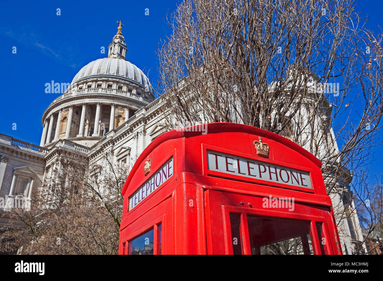 Ville de Londres un téléphone rouge traditionnel fort à St Paul's Cathedral Gardens contrastant avec la Cathédrale elle-même Banque D'Images