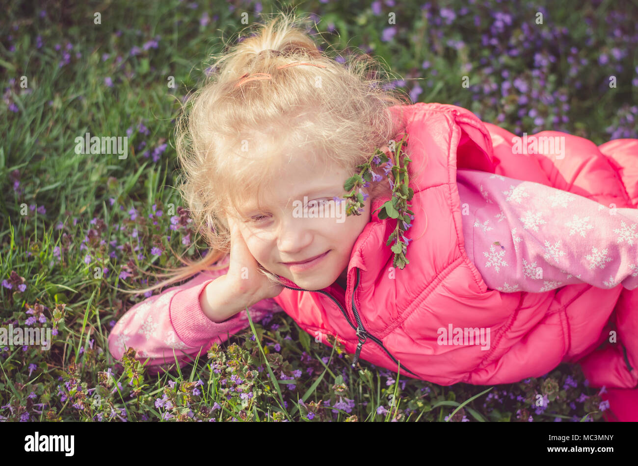 Adorable petite fille blonde à l'odeur de fleurs nature printemps Banque D'Images