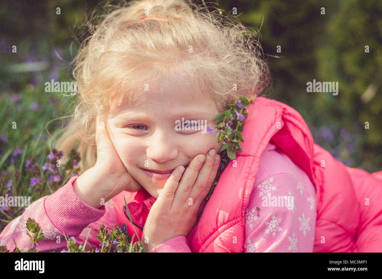 Adorable blonde girl smiling in the meadow portrait Banque D'Images