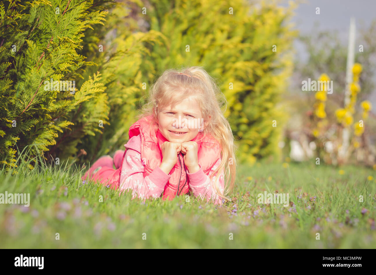 Adorable petite fille blonde à l'odeur de fleurs nature printemps Banque D'Images