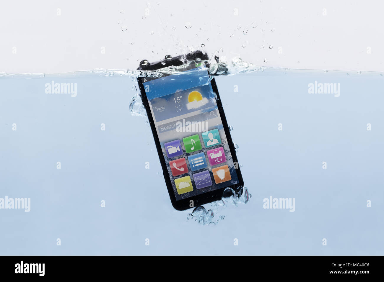 Close-up d'un nouveau téléphone mobile noir submergé dans l'eau Banque D'Images