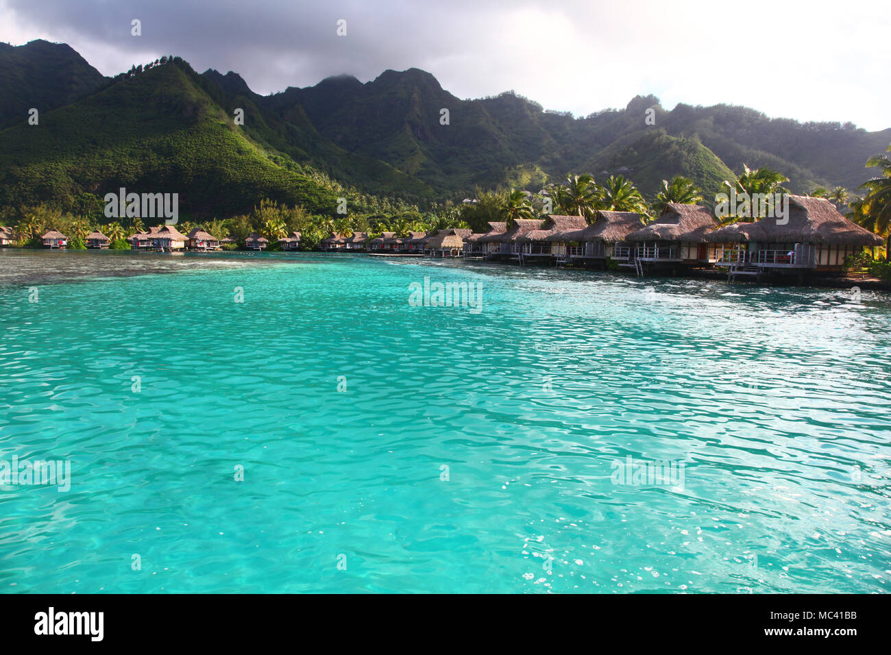 Vue vers la baie de Moorea, avec de l'eau tropical turquoise & bungalows sur la mer. Polynésie Française, Pacifique Sud. Banque D'Images