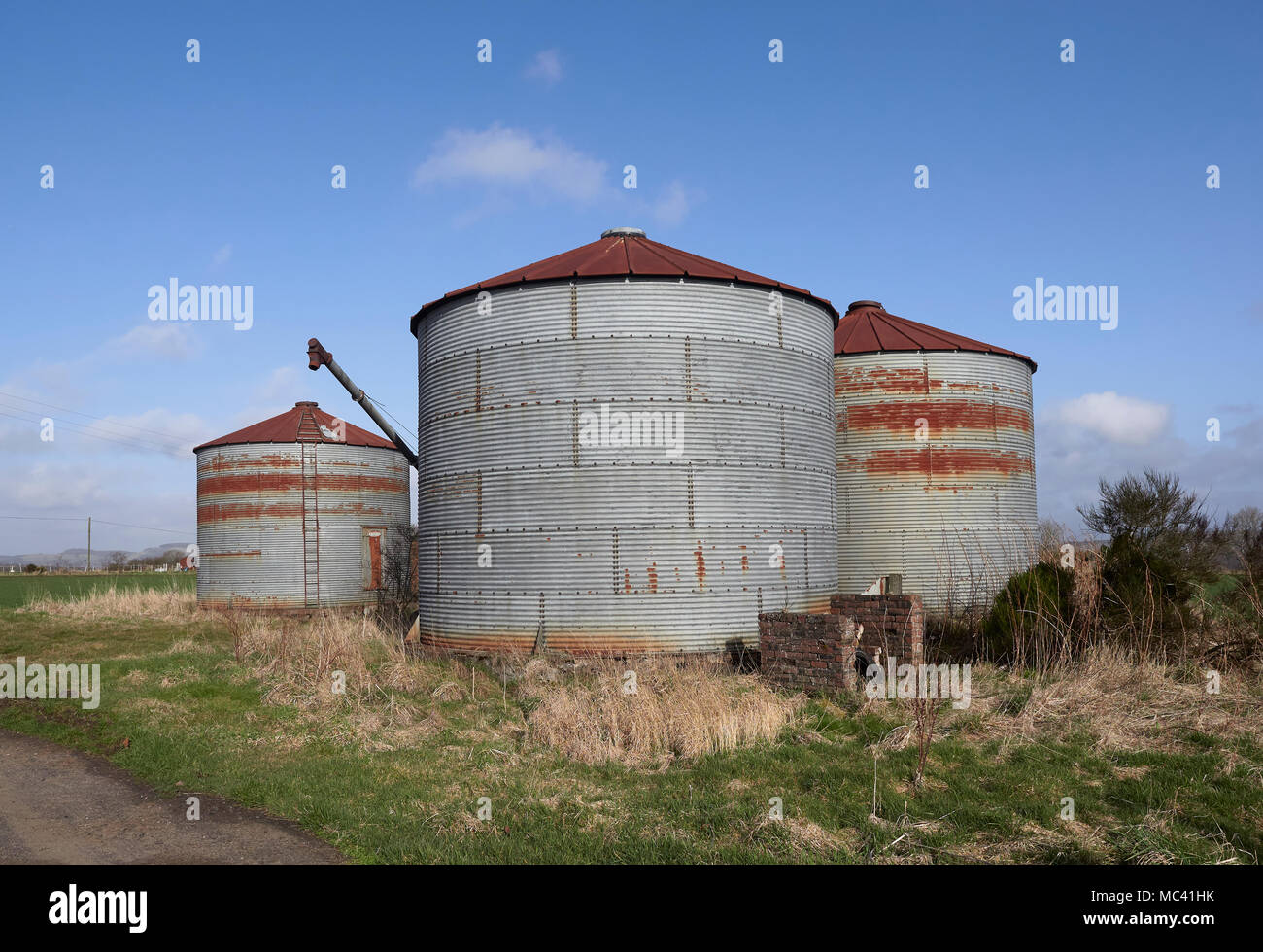 Certains de l'ancien style de rouille les silos à grains dans l'ouest de la prise secteur de Gardyne près de Letham à Angus, l'Écosse sous un ciel clair lumineux matin de printemps. Banque D'Images