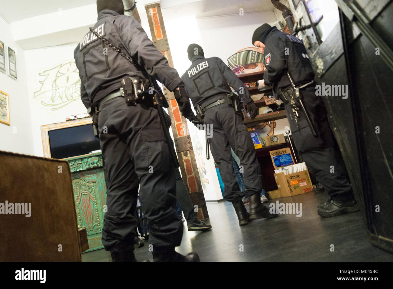 11. Avril 2018, l'Allemagne, Hambourg : policiers perquisitionner dans les locaux de la Boutique des amateurs de hip-hop '187 Strassenbande» au cours d'une descente de police dans les premières heures du matin. Un porte-parole de la police a déclaré que le raid a eu lieu pour violation présumée de la loi des armes à feu et de stupéfiants. Photo : afp/Joto Banque D'Images