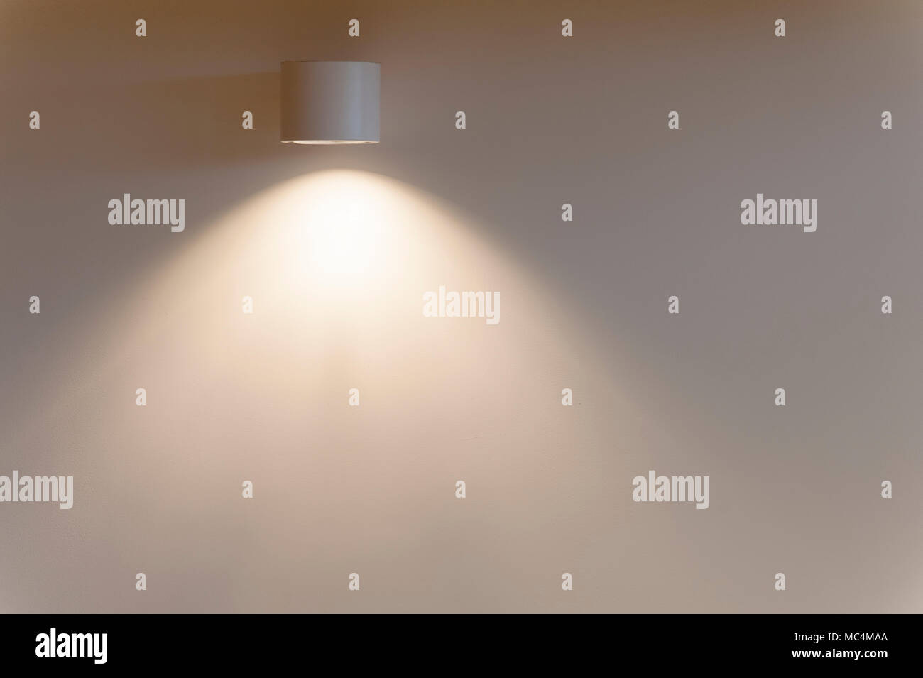 Un appareil d'éclairage directionnel sur un mur jette une lumière douce sur  un mur nu Photo Stock - Alamy
