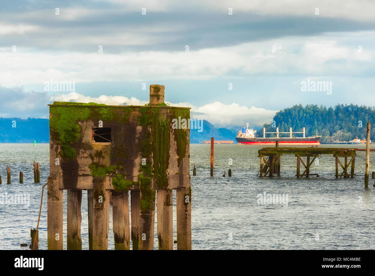 Vestiges du quai le long des rives de la rivière Columbia, à Astoria, Oregon. Un navire peut être vu dans l'arrière-plan. Banque D'Images