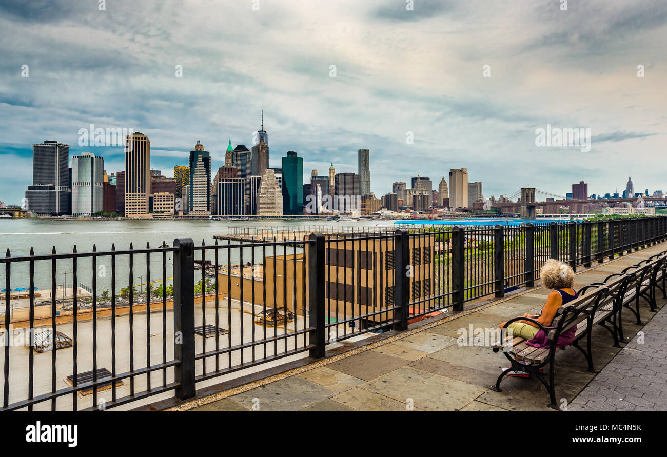 New York, NY, USA - Le 16 juillet 2014 : une femme seule non identifiés en admirant le lower Manhattan skyline de Brooklyn Heights Promenade. Banque D'Images