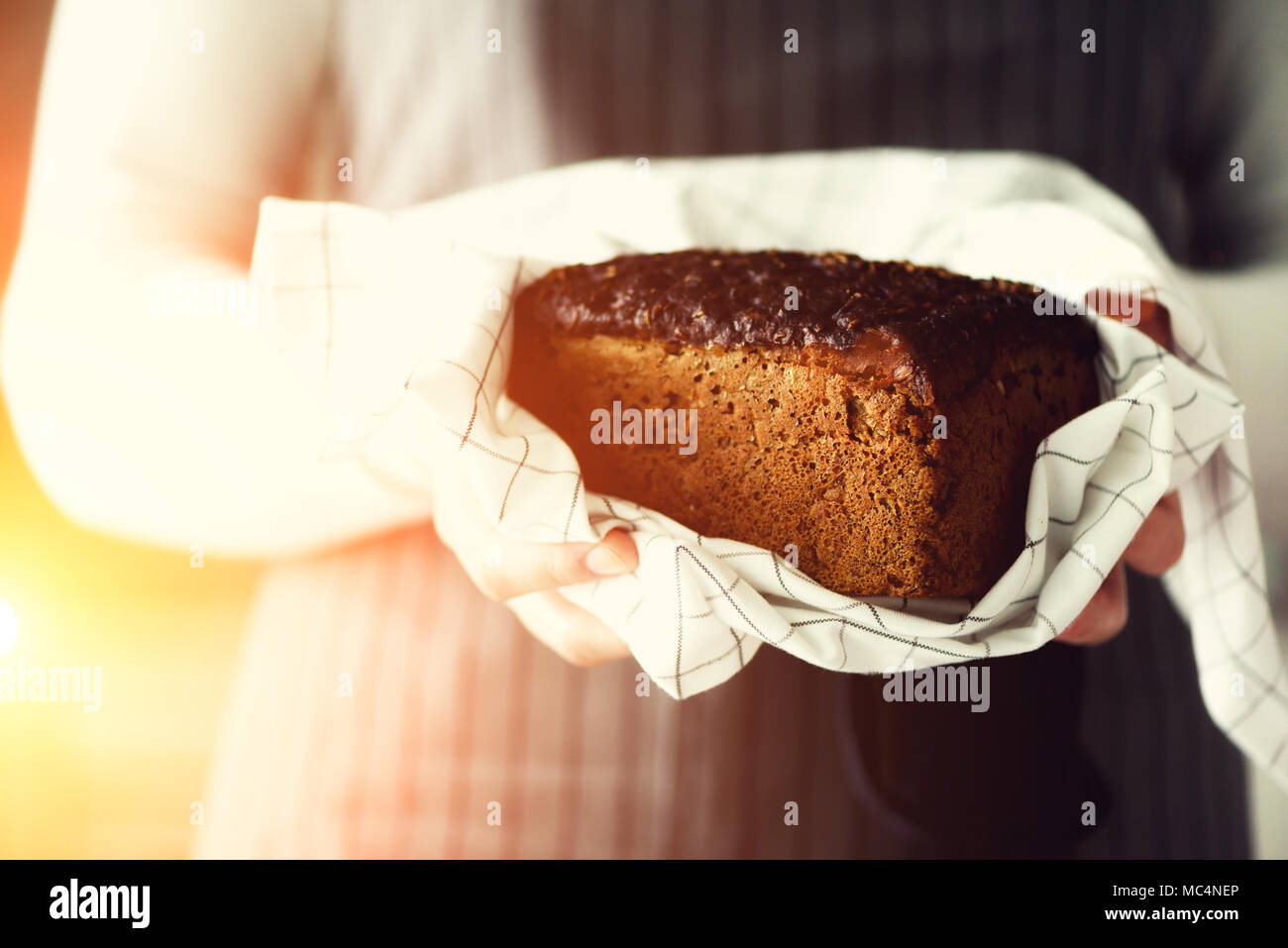 Femme mains tenant du pain frais. Miche de pain brun fait main, concept de boulangerie, une cuisine maison saine alimentation. Copy space Banque D'Images