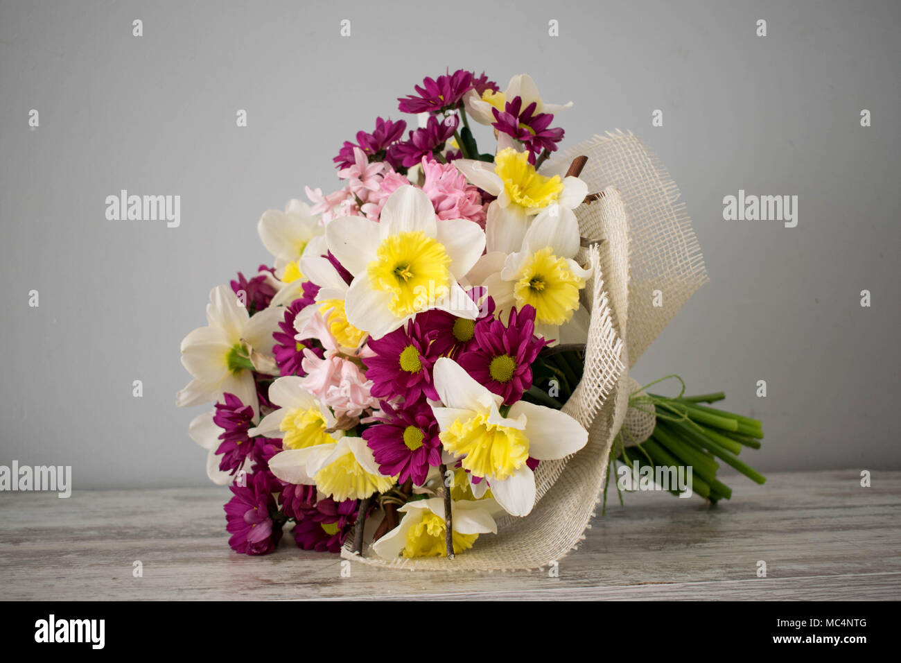 Bouquet de fleurs fraîches beau Narcisse,oeillets, chrysanthème en rose et  jaune sur le mur gris Photo Stock - Alamy