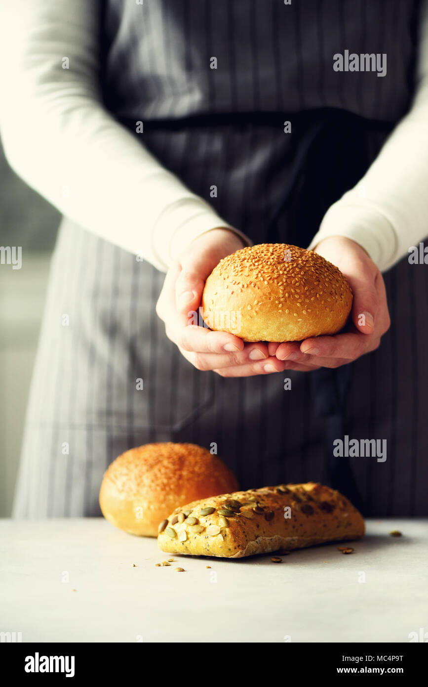 Femme mains tenant du pain frais. Bun, cookie, concept de boulangerie, une cuisine maison saine alimentation. Copier l'espace. Bannière. Banque D'Images